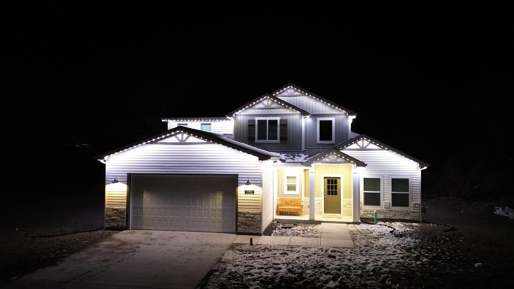 Bright white roofline lighting on a two-story home at night