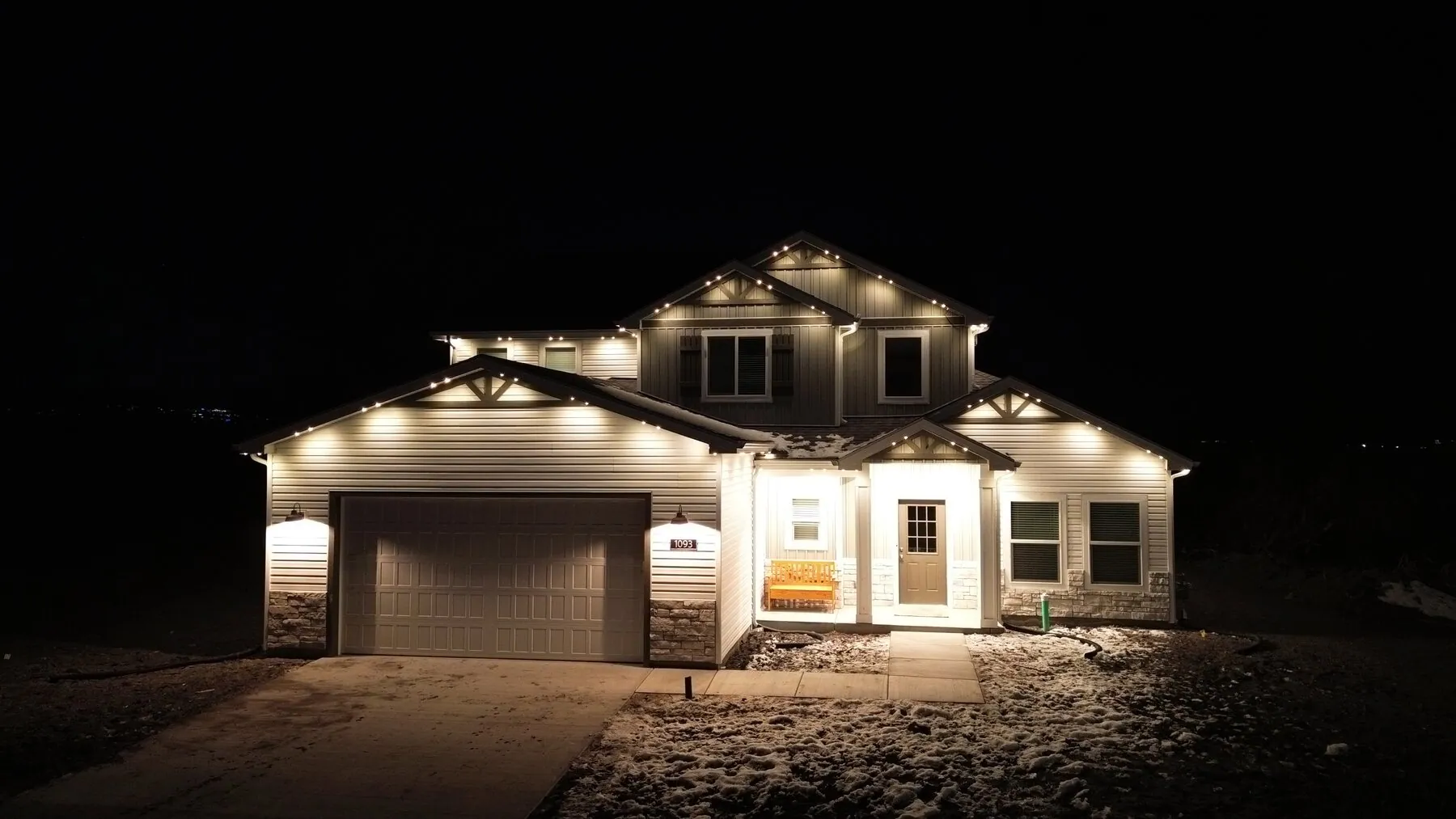 Warm white lighting along a home's roofline and garage
