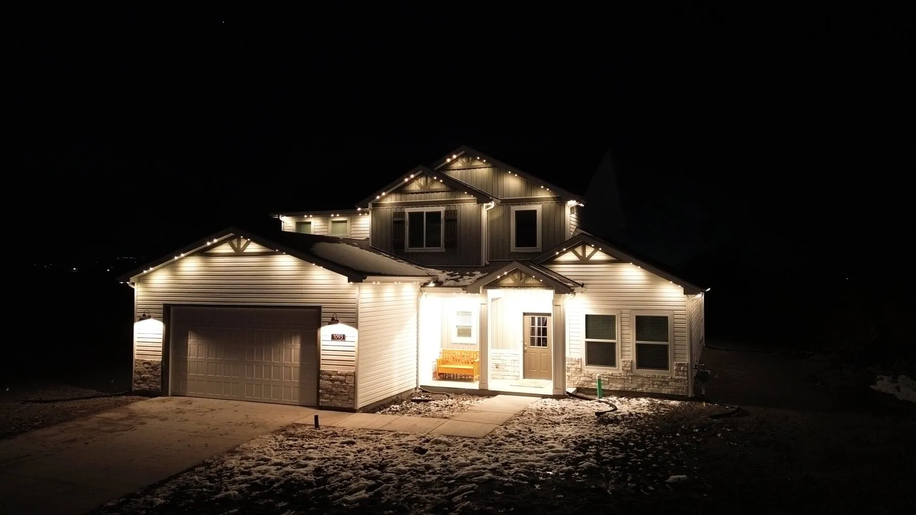 White permanent lighting on a two-story home's gables