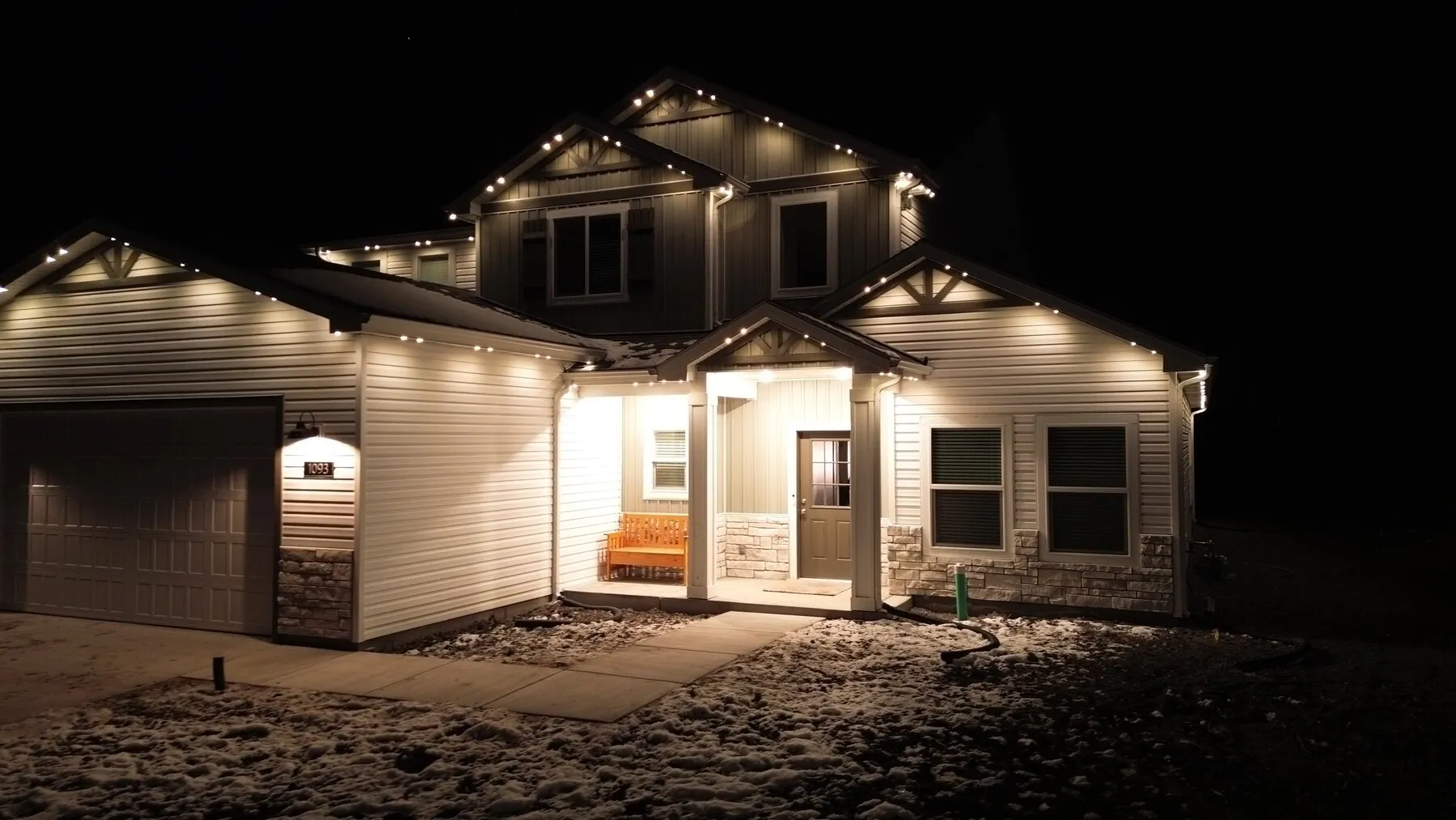 Warm white roofline lighting on a home with a covered entry