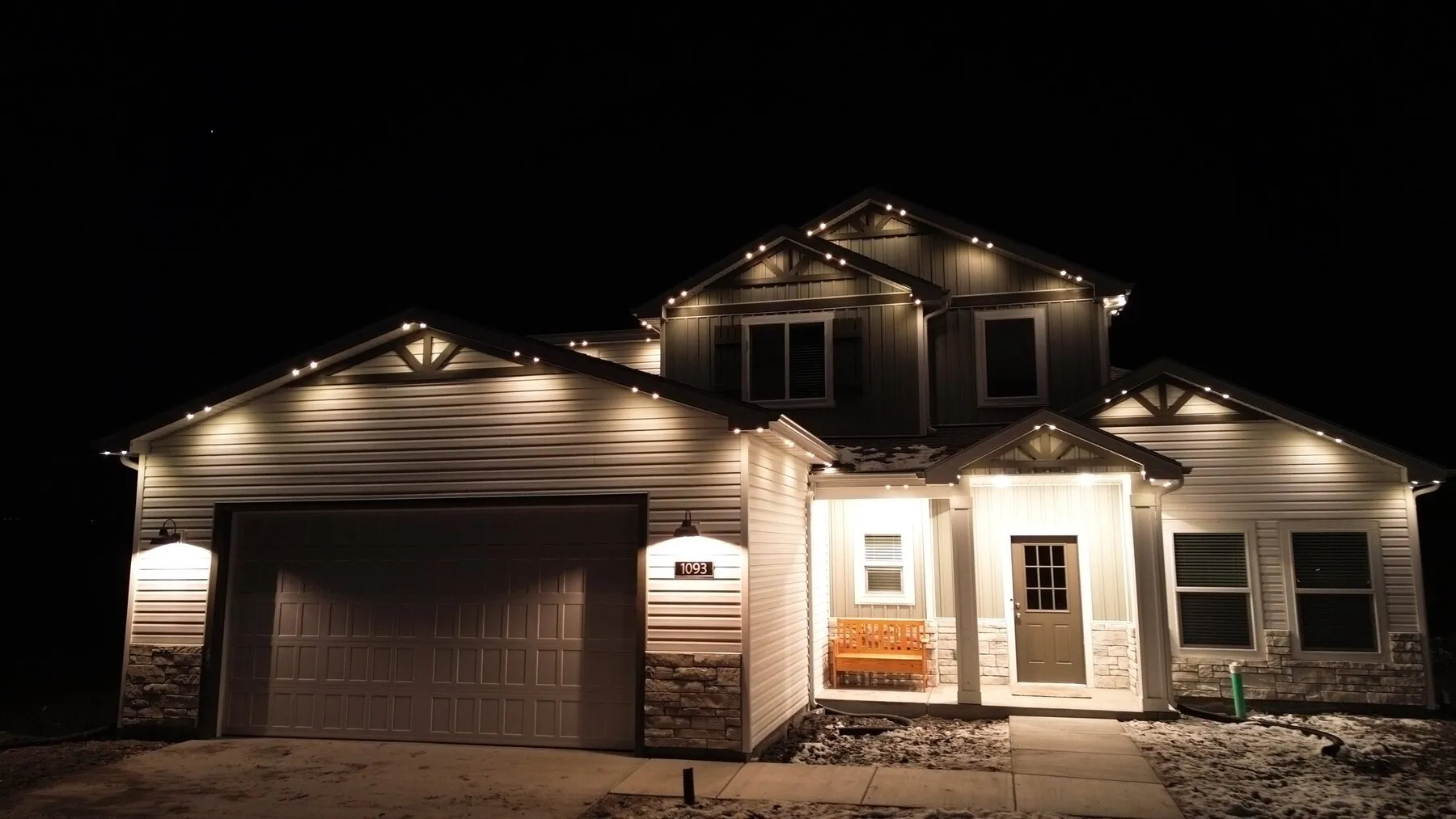 Warm downlighting along a home's eaves and garage