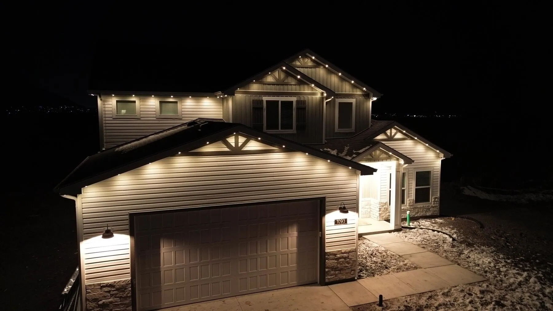 White roofline lighting on a two-story home viewed from the driveway