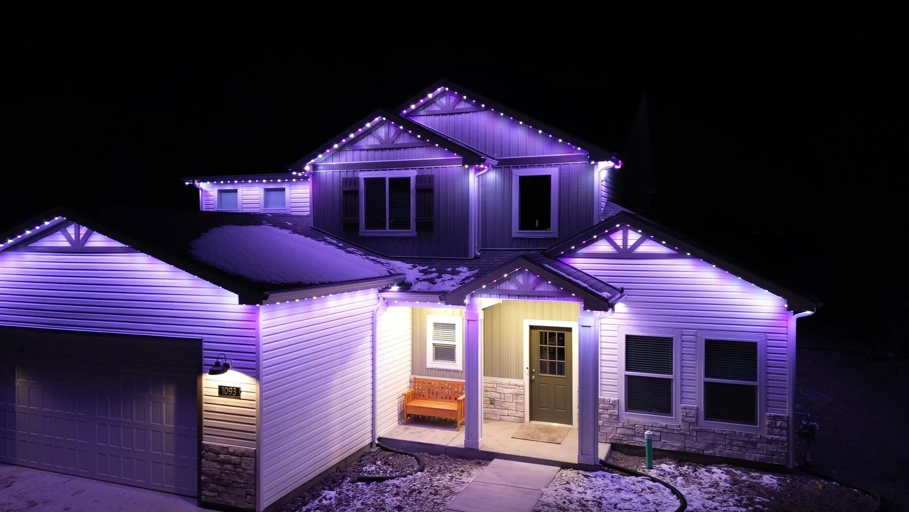 Violet roofline and downlighting on a two-story home
