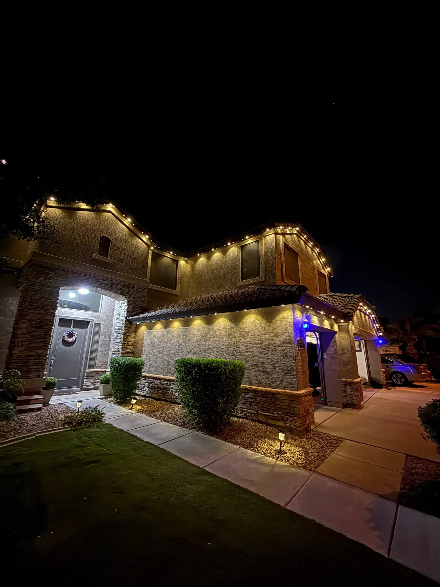 White permanent roofline lighting on a home at night
