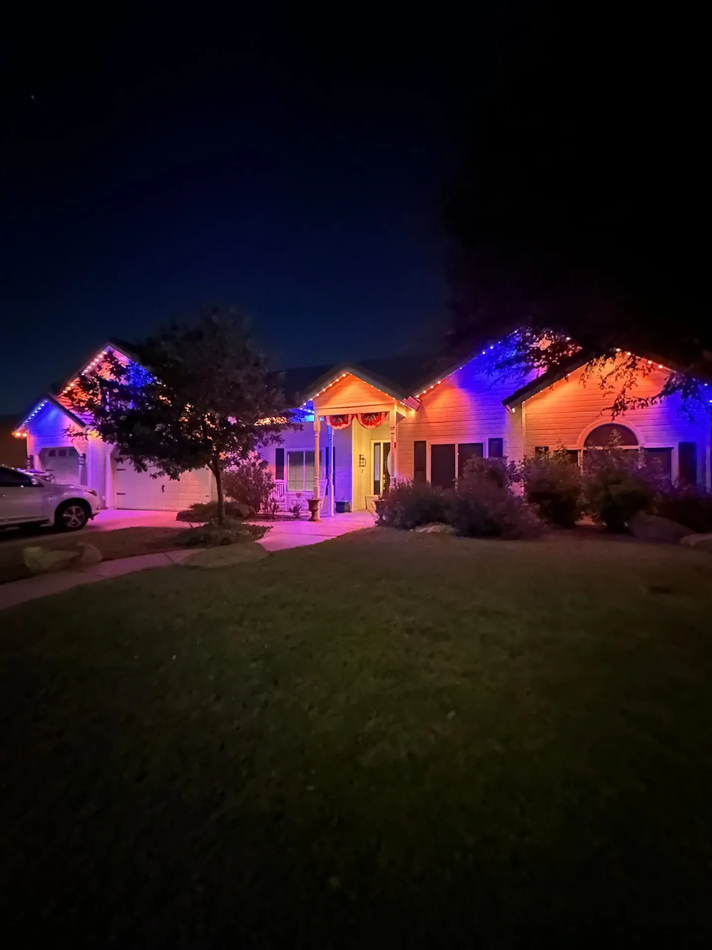 Orange and blue permanent holiday lighting on home