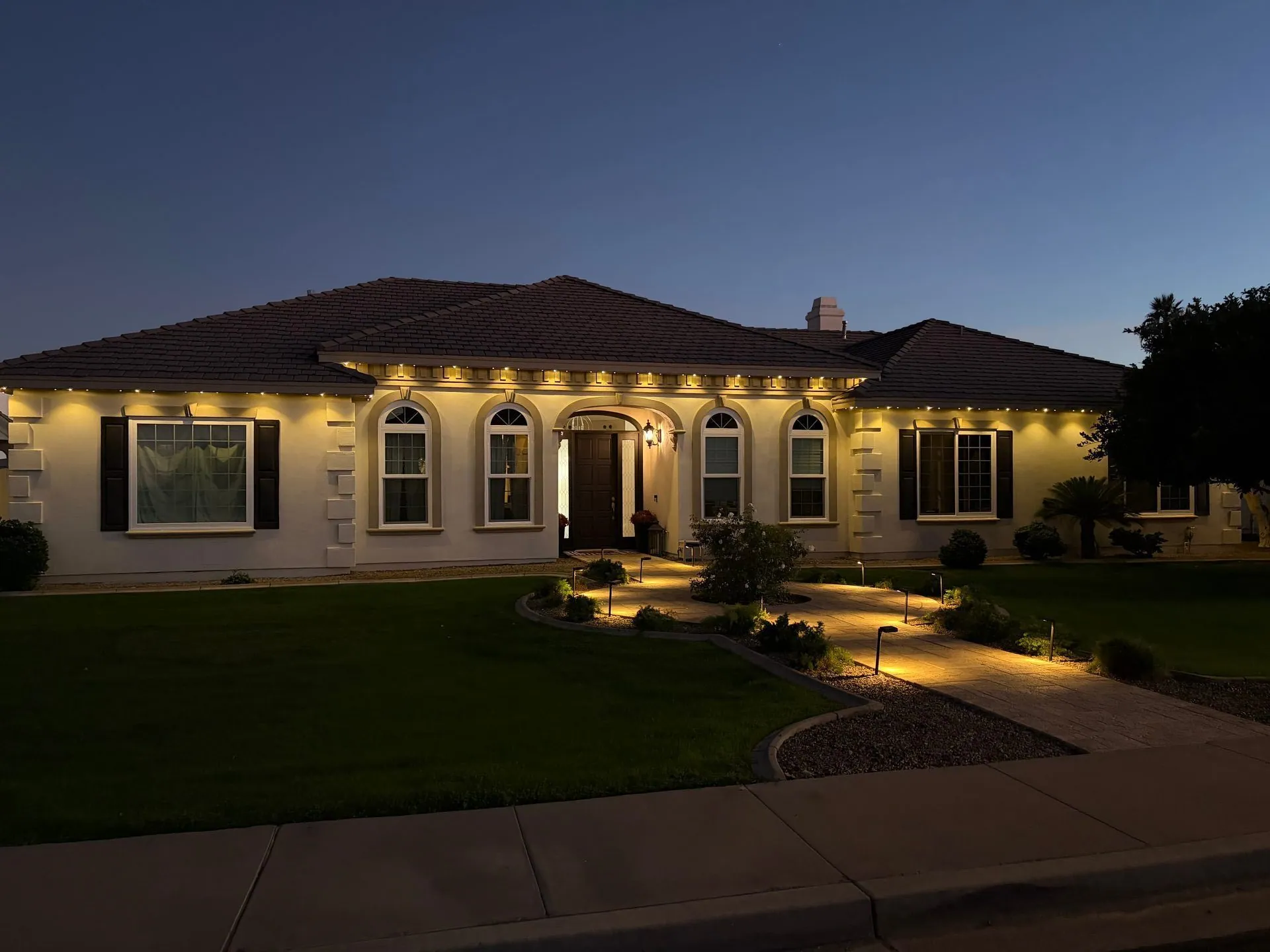 Permanent lighting enhancing Mediterranean home curb appeal