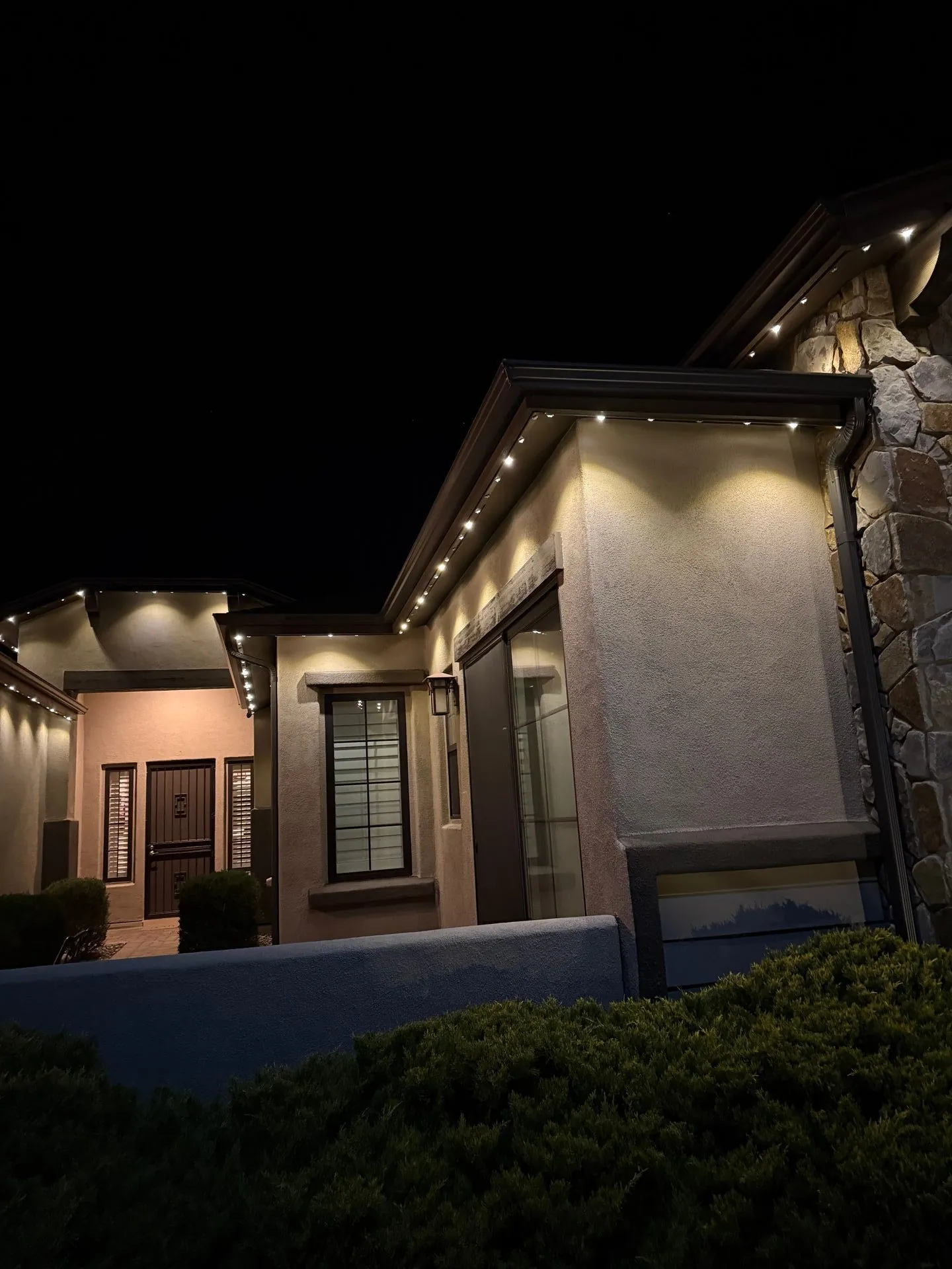 Permanent roofline lighting on modern home at night