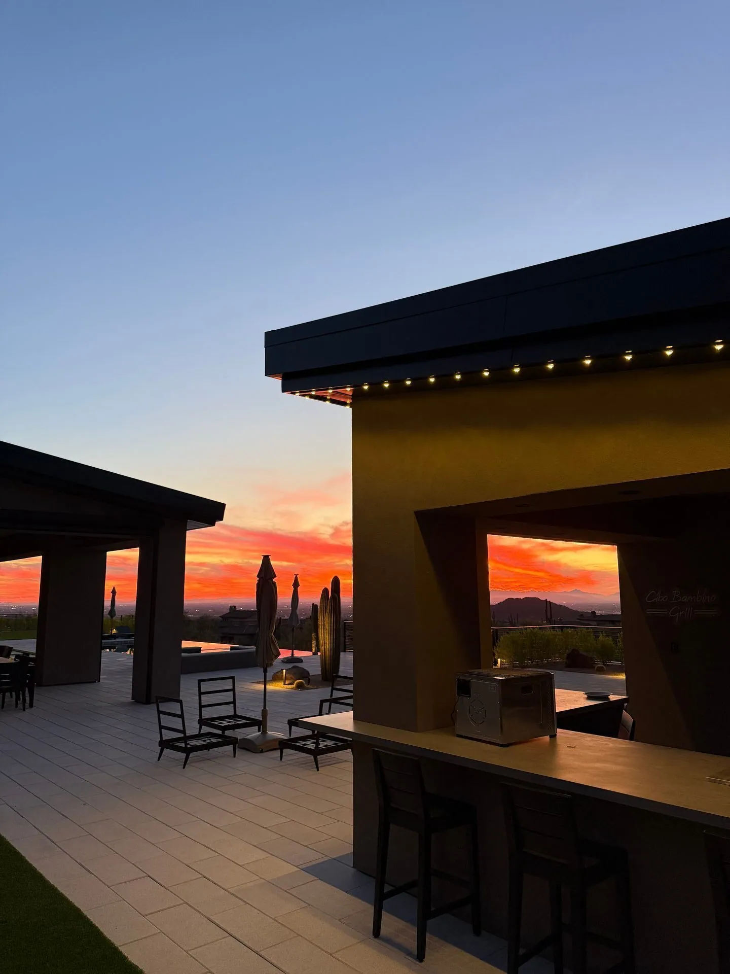 Permanent lighting on outdoor kitchen and bar at sunset