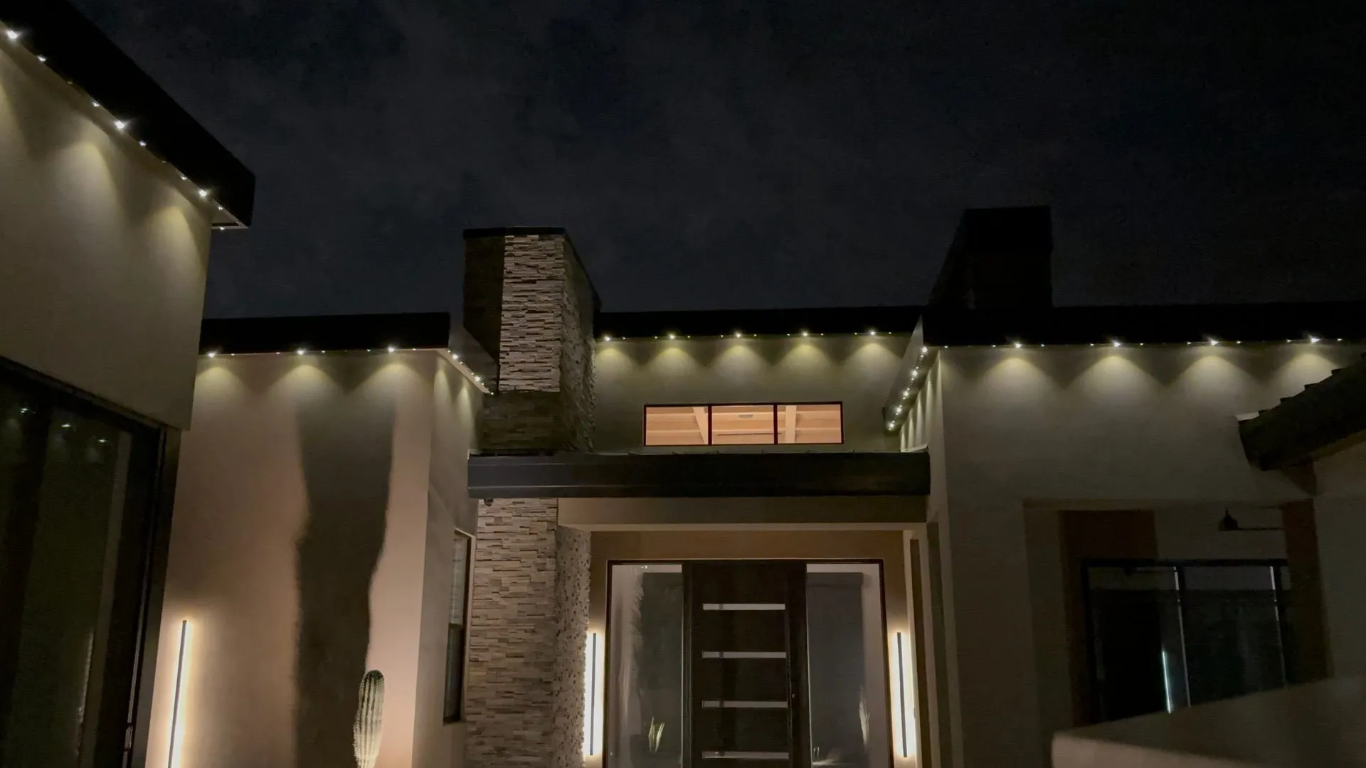Permanent lighting illuminating modern home entry at night