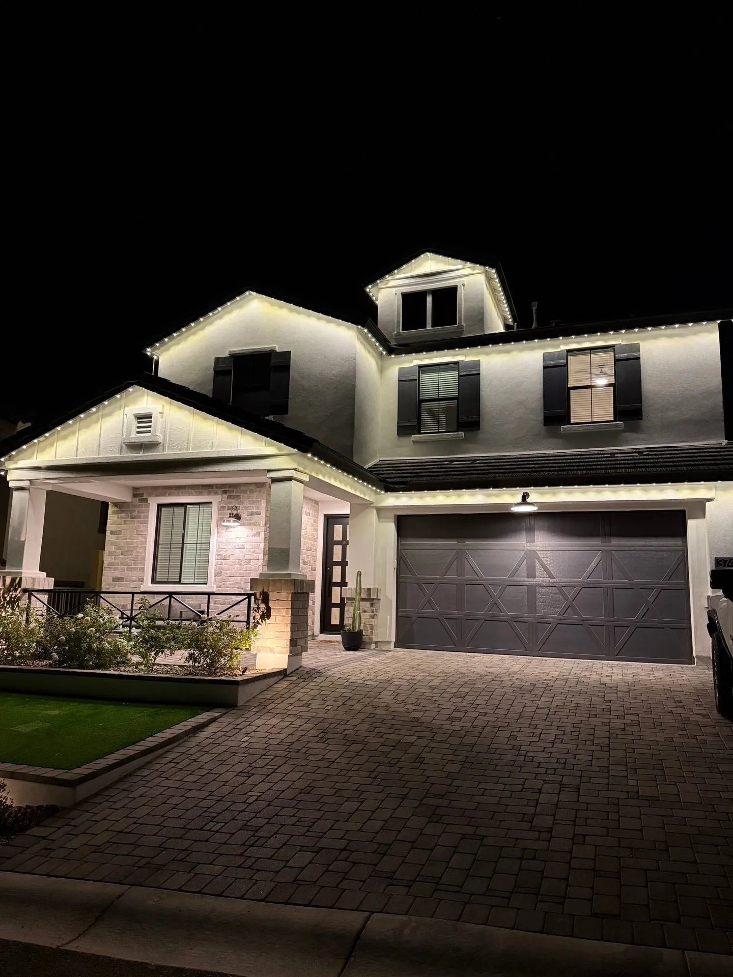 Two-story home with bright white permanent roofline lighting