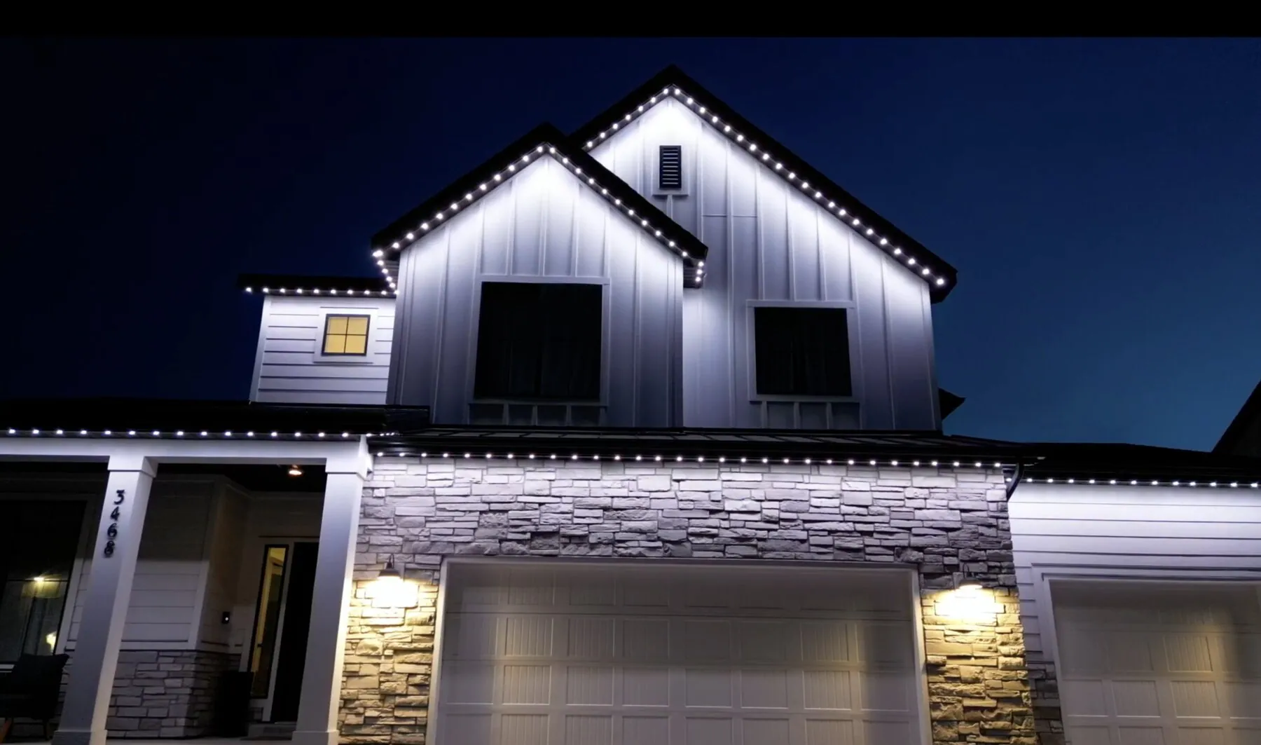 Bright white roofline lighting on a modern two-story home