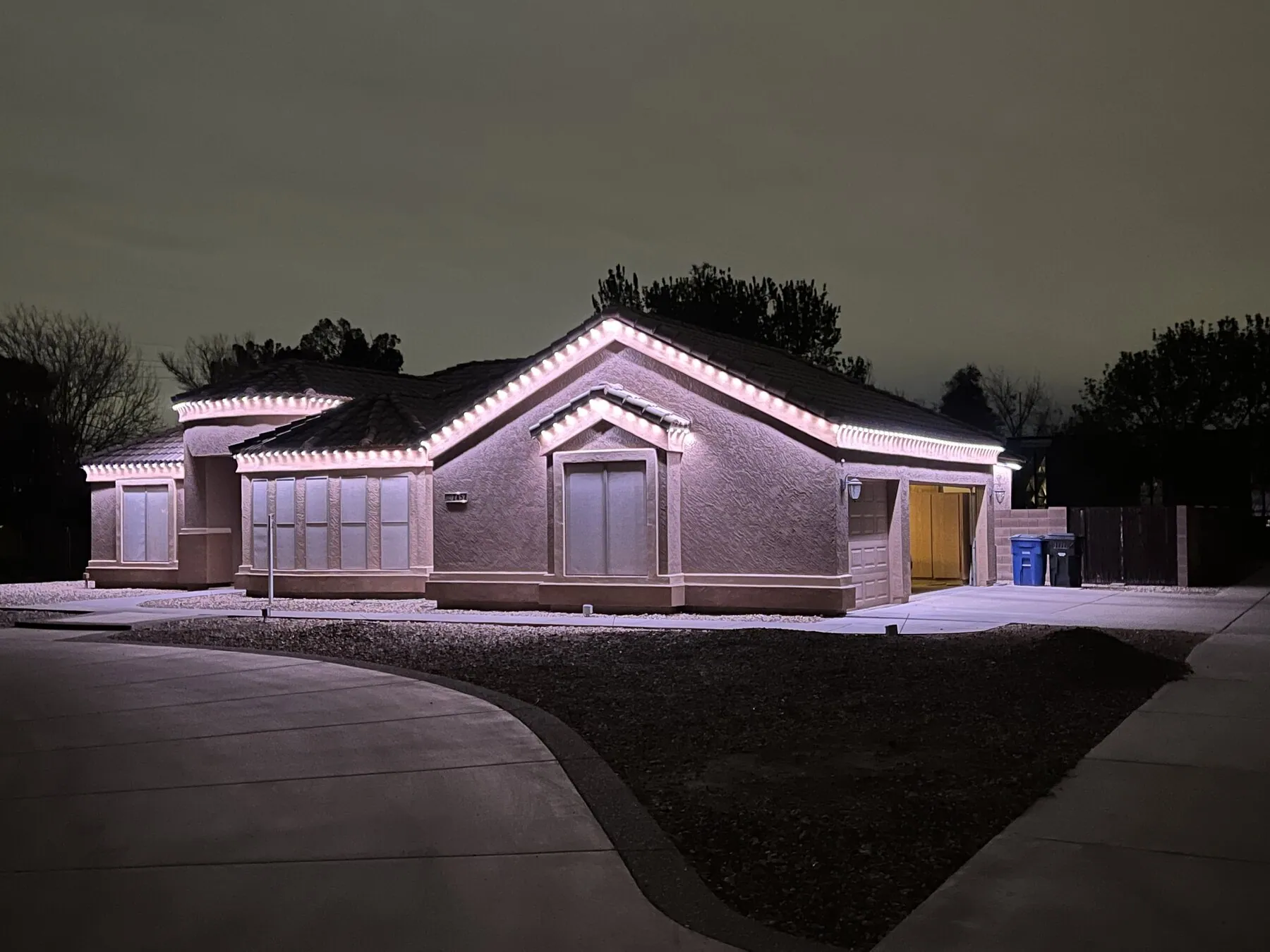 White roofline lighting on a single-story home at night