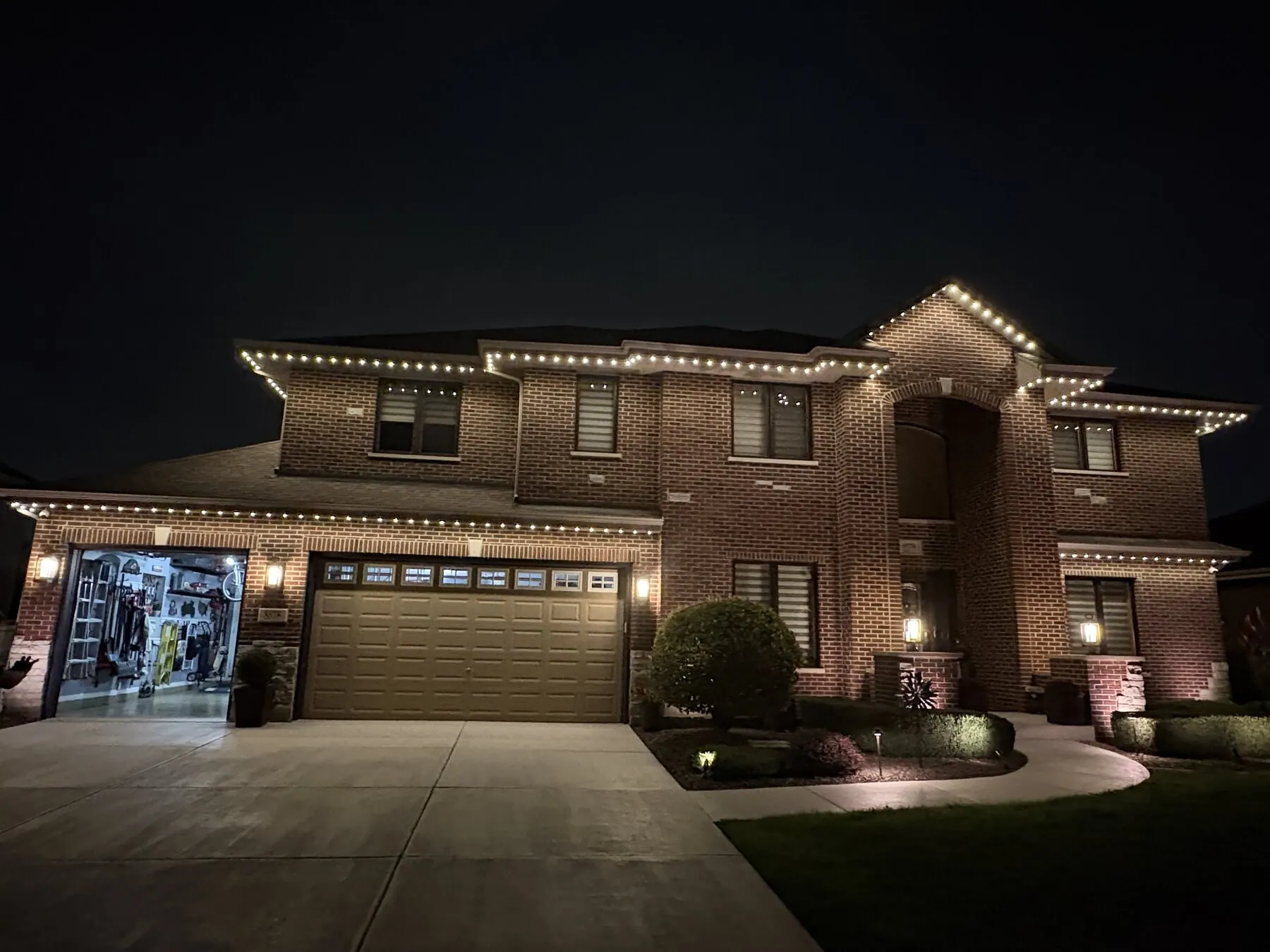 Warm white roofline lighting on a large two-story home
