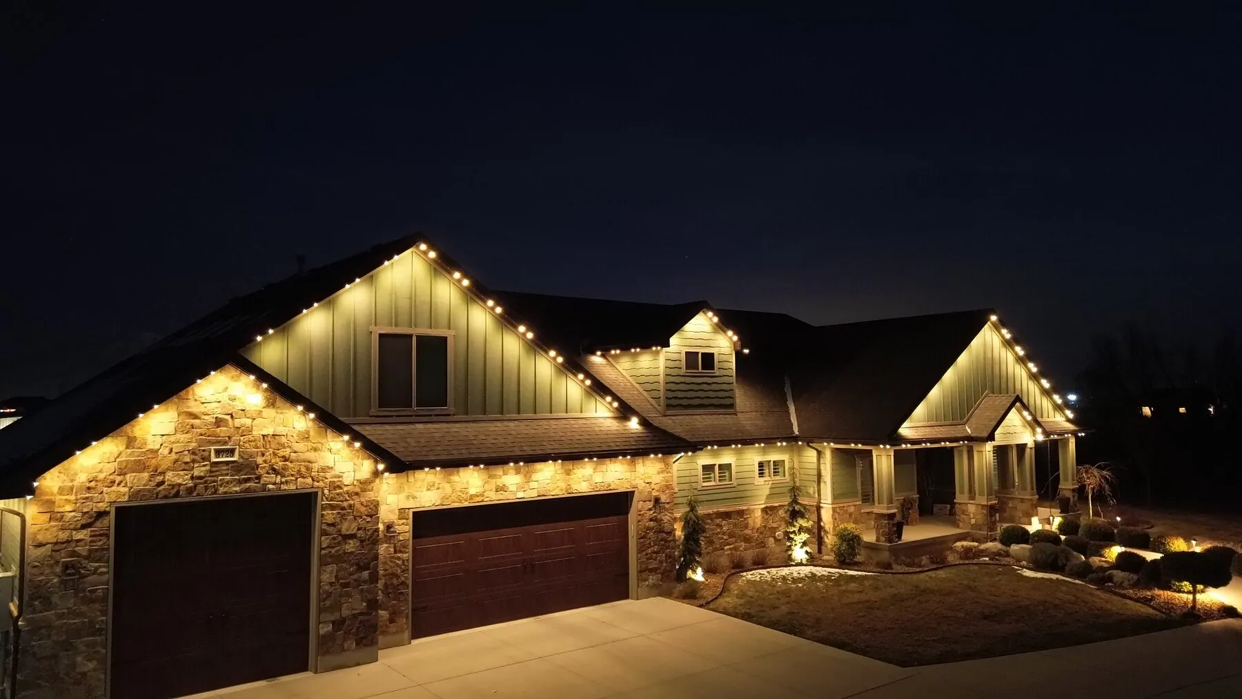 Warm roofline lighting on a large home at night