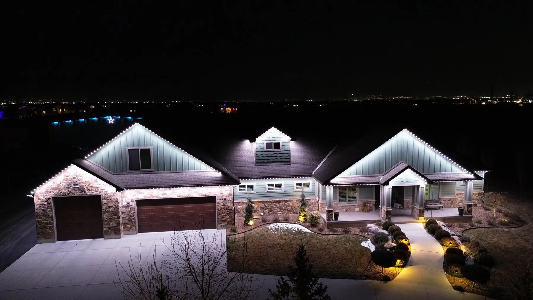 Aerial view of white permanent lights along several gabled rooflines