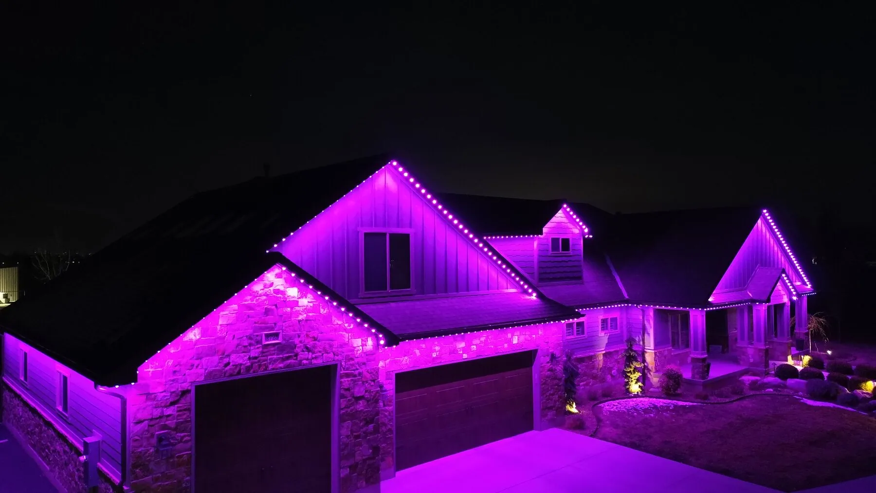 Vibrant purple roofline and accent lighting on a home
