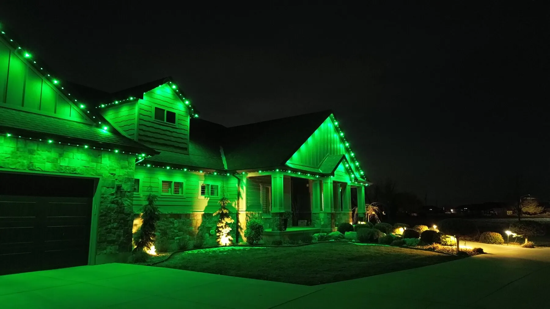 Green permanent lighting illuminating a home's front exterior