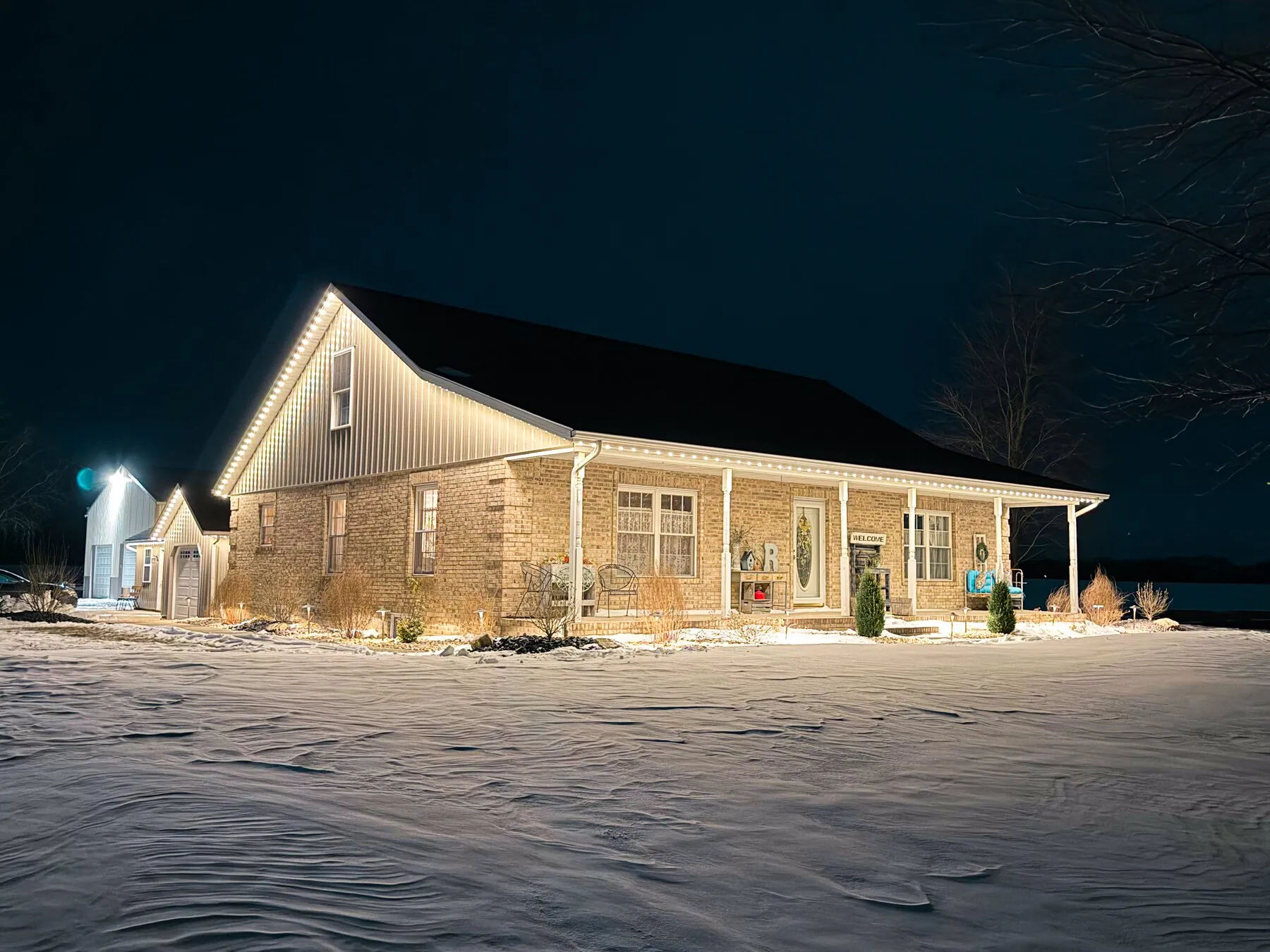 Warm exterior lighting on a house surrounded by snow
